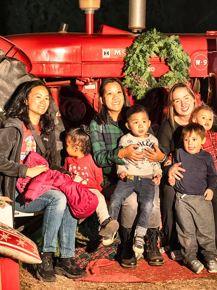 A family posing on the big red tractor photo op