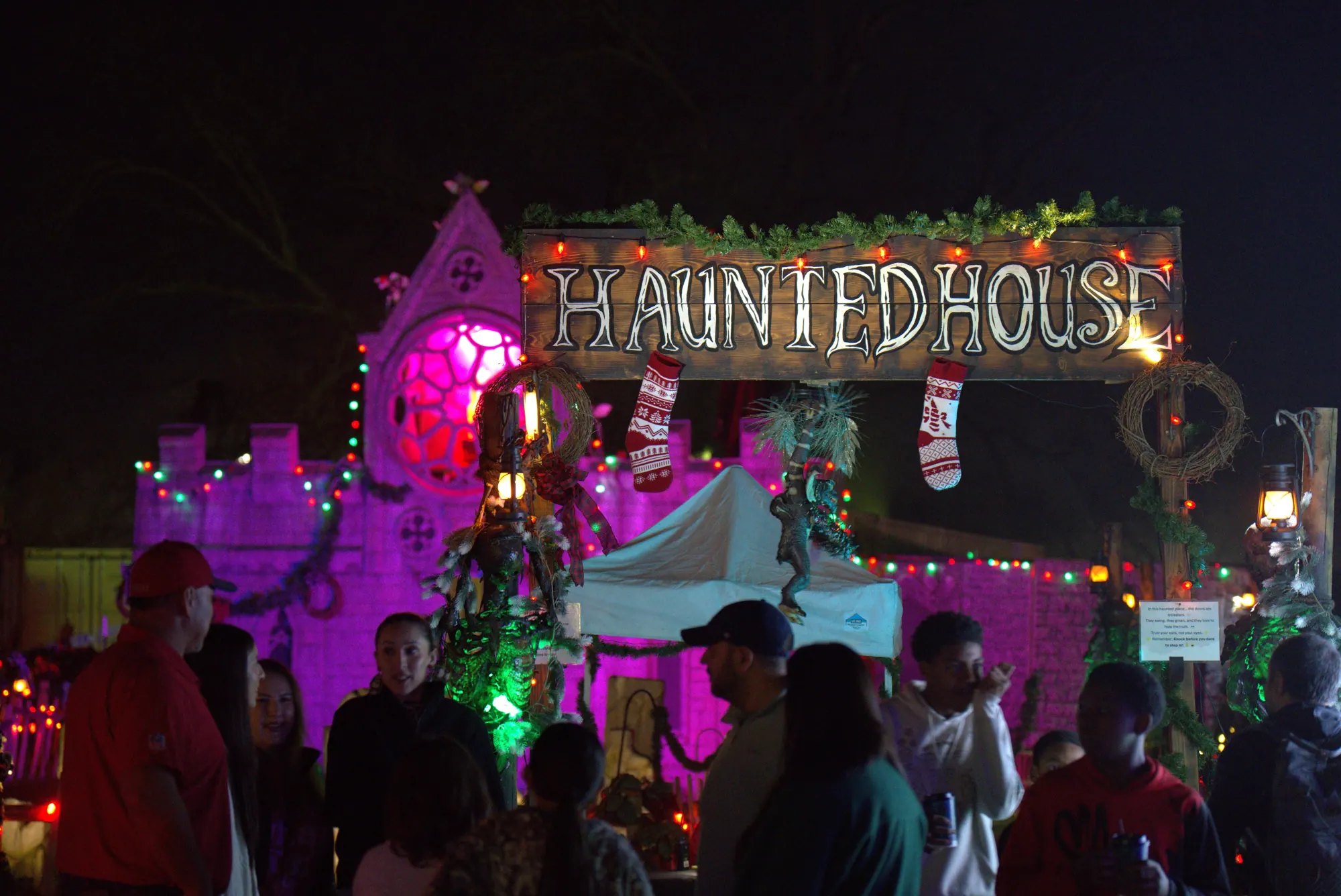 Guests lined up outside the glowing pink Haunted House