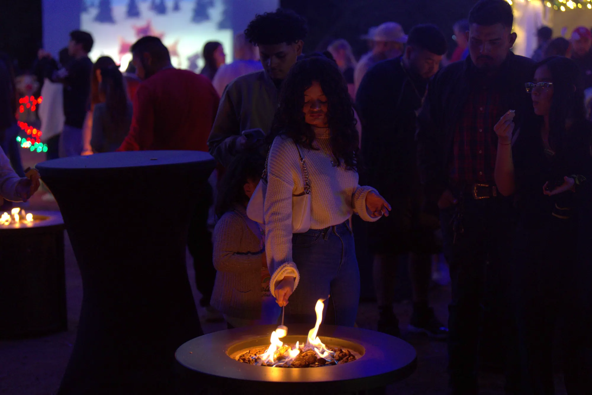 A guest toasting a marshmallow over a fire pit